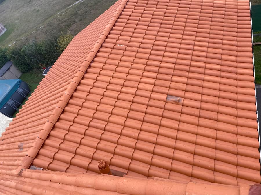Arêtiers et tuiles neuves sur une toiture rénovée